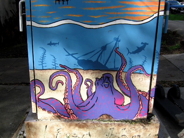 An octopus at the bottom of the sea near a wrecked tall ship.