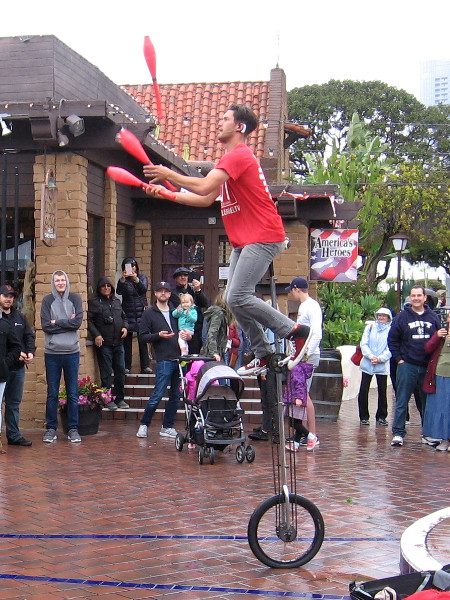 Daniel Israel juggles while high atop a unicycle!