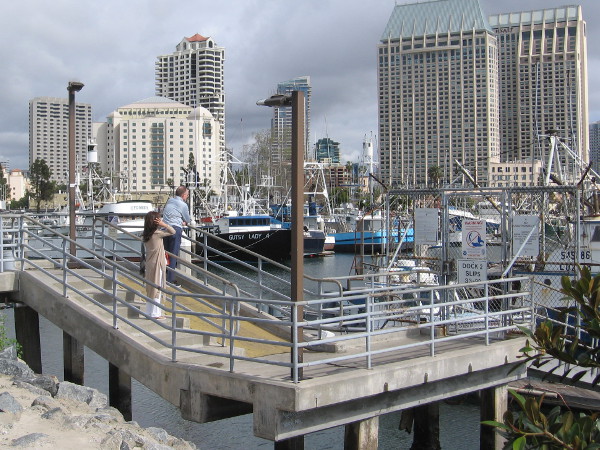 A couple pauses to gaze at fishing boats in Tuna Harbor.