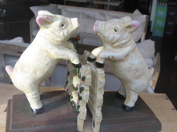 Two neighbors have a friendly oink over their fence.