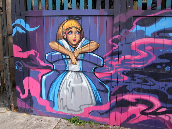 Alice gazes out at Adams Avenue from a fence behind White Rabbit Day Spa.