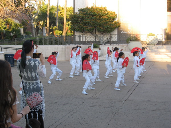 Kids representing the Confucius Institute perform kung fu fan moves in front of the Timken Museum of Art.