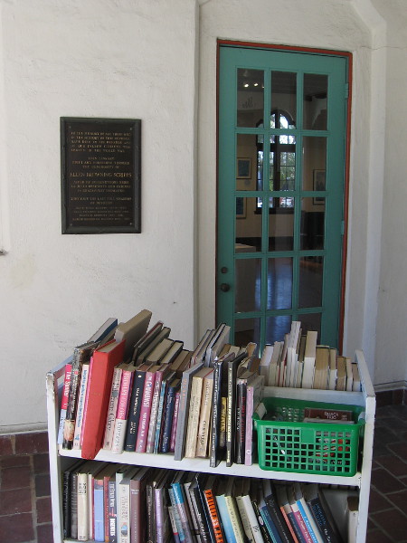 A library cart full of books entices passersby.