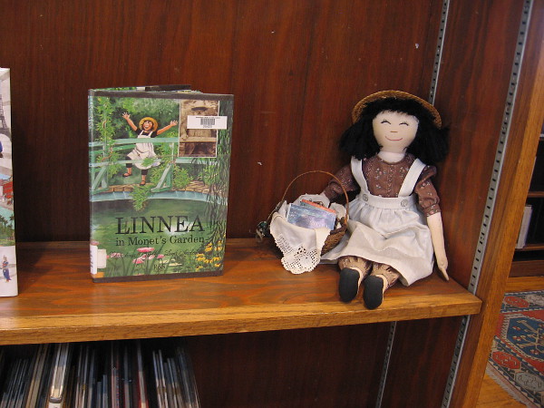 Linnea doll on shelf by the book Linnea in Monet's Garden.