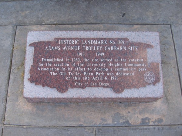 Plaque at base of post reads: HISTORIC LANDMARK No. 369 - ADAMS AVENUE TROLLEY CARBARN SITE 1913 - 1949 . . . The Old Trolley Barn Park was dedicated on this site April 6, 1991.