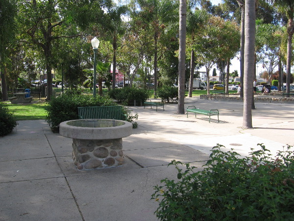 What appears to be a round table in the park contains an interesting plaque that remembers when trolleys ran through University Heights.