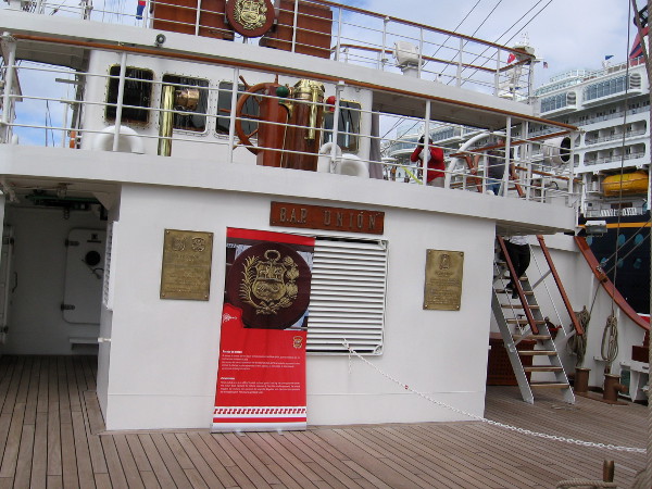 I've turned about to face the ship's stern. I see plaques, the ship's wheel and the ship's bridge.