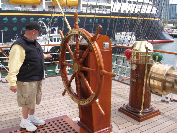 A visitor aboard the BAP Unión checks out the impressive ship's wheel.
