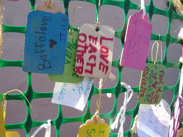 Many messages dangle from the Love Wall. Love each other.