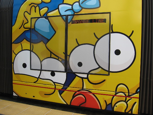 Marge and Maggie Simpson on the other side of the trolley.