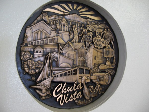 Large sculpted medallion in a wall near the entrance to the Chula Vista Public Library. Scenes depicted include Rohr Aircraft Company, the San Diego Country Club, home of golf legend Billy Casper.