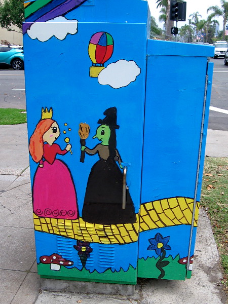 The Good Witch of the North and The Wicked Witch of the West meet on the yellow brick road, as a balloon flies away in Oz.