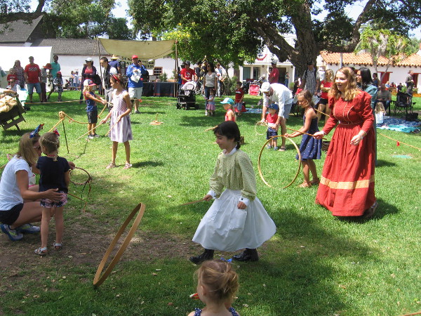 Kids have fun with hoops on the grass. Simple play from an age long past.