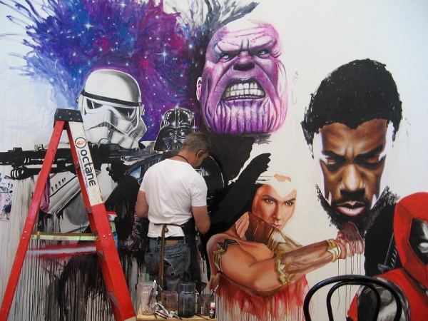 Rob Prior works on a mural that includes several well-known pop culture characters.