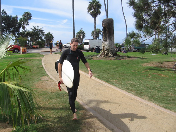 Here comes another surfer, heading through the park by the Swami's Beach parking lot. It appears he finished surfing at Swami's Reef for the day.