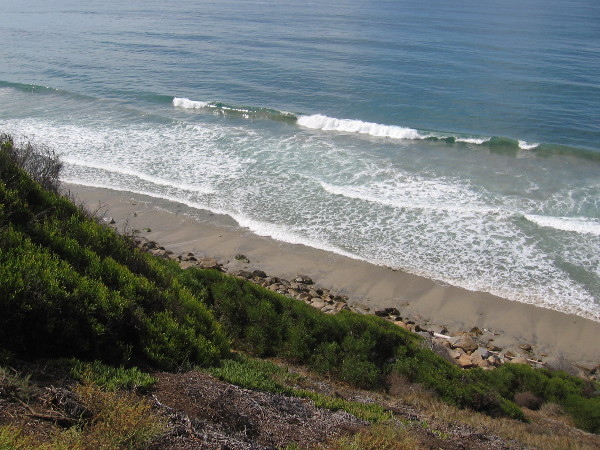 The surging Pacific Ocean and the narrow beach below.