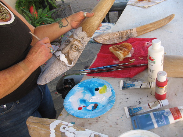 Artist paints a face at the Spanish Village Art Center.