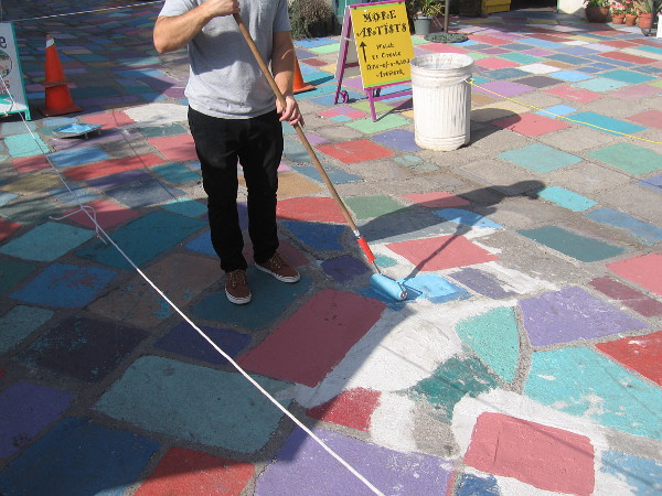 Painting the colored tile patio of Spanish Village.