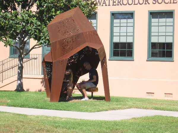 Instead of speaking face to face, two people stare silently down at their phones.