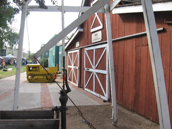 Looking backward through the windmill, we see an old tractor parked in front of the Penner Barn.
