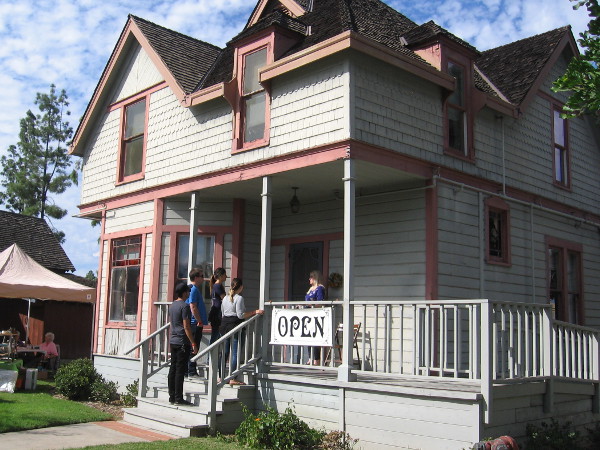 A small tour group assembles on the front porch.
