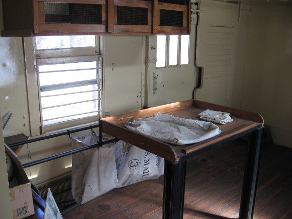 Sacks of mail were transported at one end of the railroad car.
