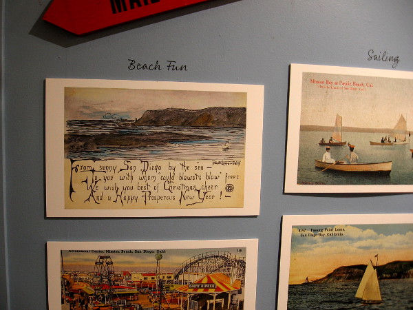 Diverse themes in the postcard exhibit include beach fun and sailing.