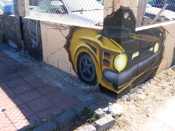 A new mural along a low wall at Tito's Auto Body depicts cool cars. The public art is a project of Love City Heights and #TheAvenueMuralProject.