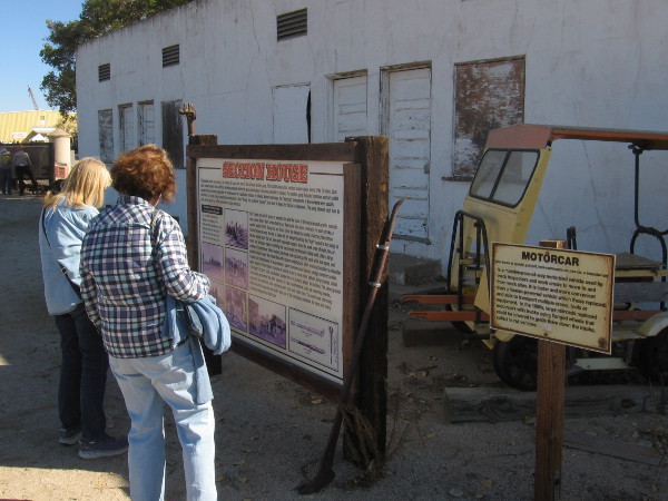 Reading a sign by the railway Section House, where railroad workers were housed along the track.