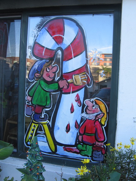 Santa's elves are painting a huge candy cane.