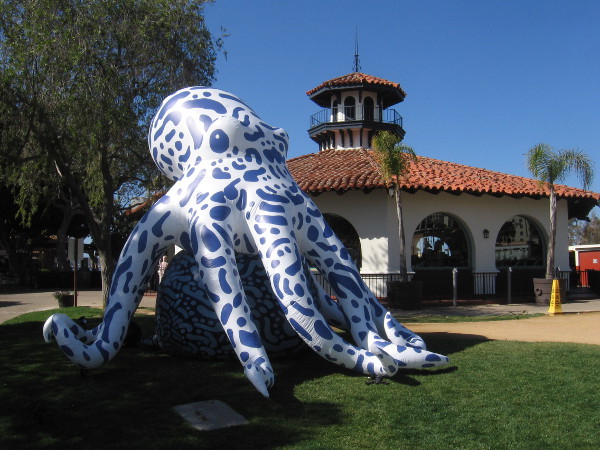 A gigantic octopus is standing on the grass near the Seaport Village carousel!