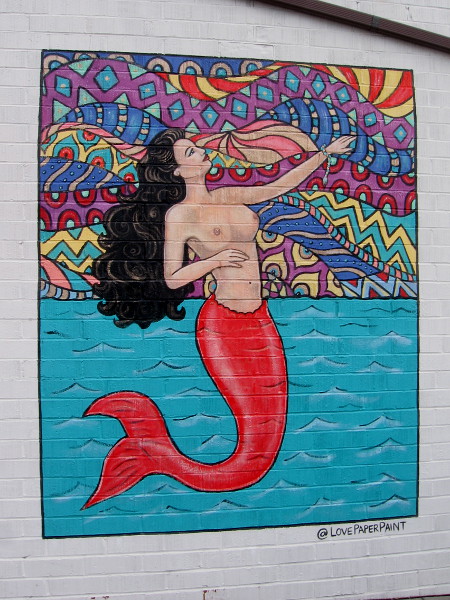 A mermaid mural by @LovePaperPaint (Katie Gaines) is inspired by the traditional La Sirena image in Mexican Lotería.