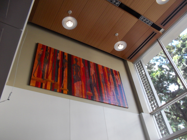 Colorful art near the ceiling as I walk up some beautiful stairs.