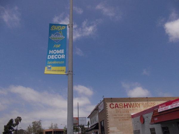 Banner on lamp post invites people to Shop for Home Decor in the Morena District.