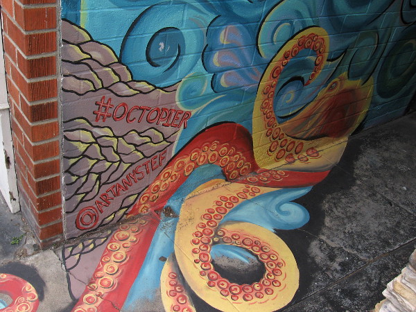 Bottom of the alley mural, with an octopus tentacle wearing a beach sandal. #octopier by @artanystef.