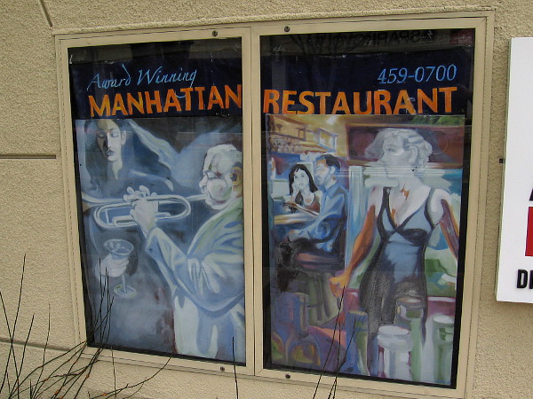 Stylish, jazzy posters on a building advertise the Manhattan of La Jolla restaurant.