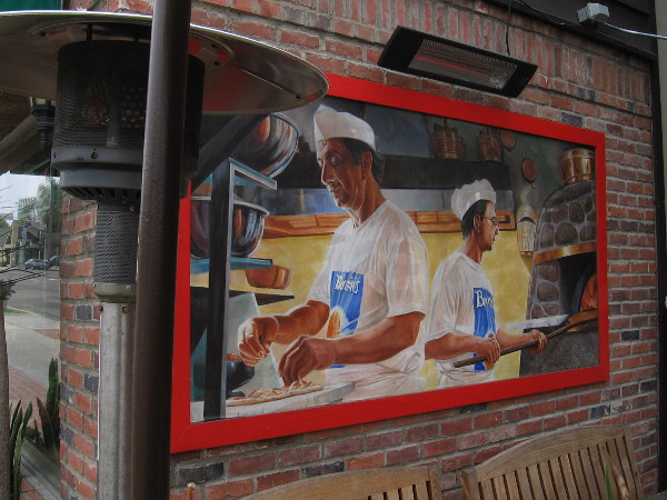 Small mural on the outdoor patio of Bernini's Bistro shows pizzas being prepared.