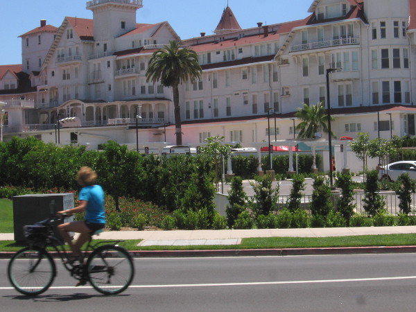 Bicyclist heads down the street, with the Hotel del Coronado in the background.