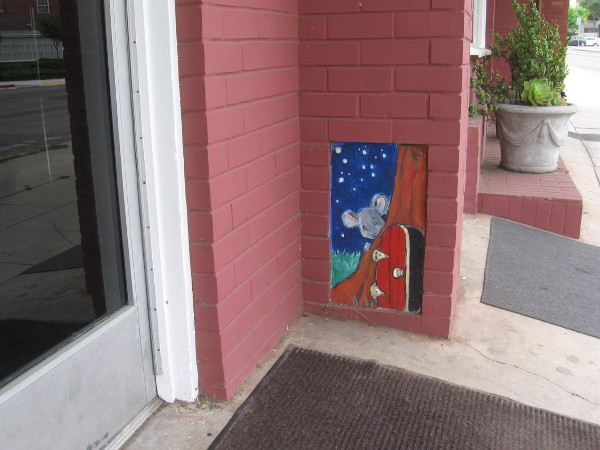 A mouse has a secret door near the ground by the door of a Point Loma business.