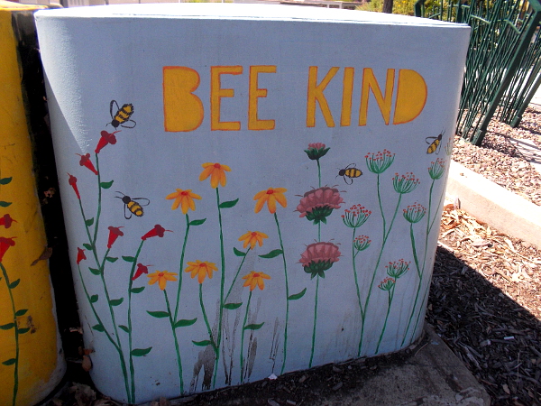 Another nearby electrical box reads BEE KIND.