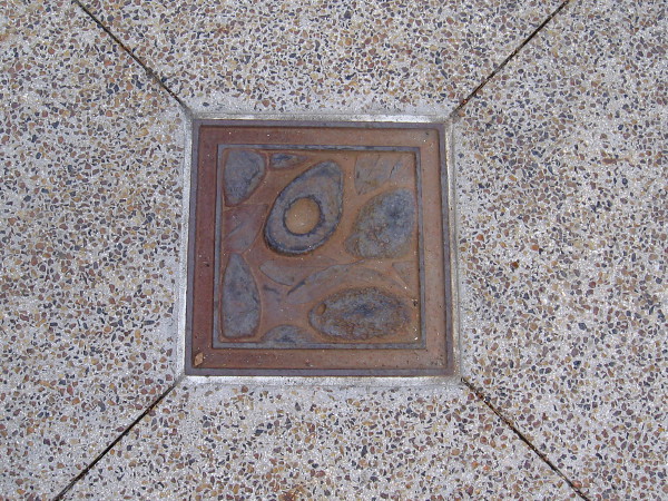 Plaques set in the Paseo Santa Fe sidewalk contain sculpted avocados.