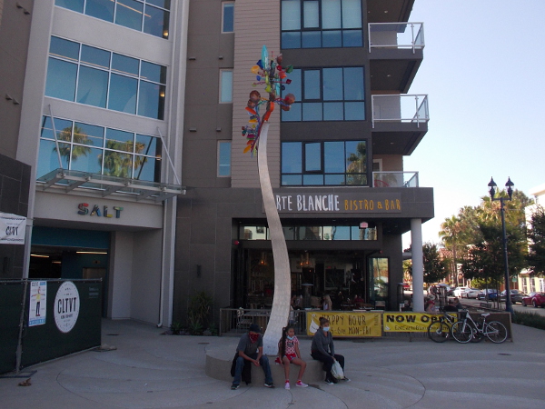 A tall, kinetic wind sculpture in Oceanside, California by artist Andrew Carson, in front of the SALT building.