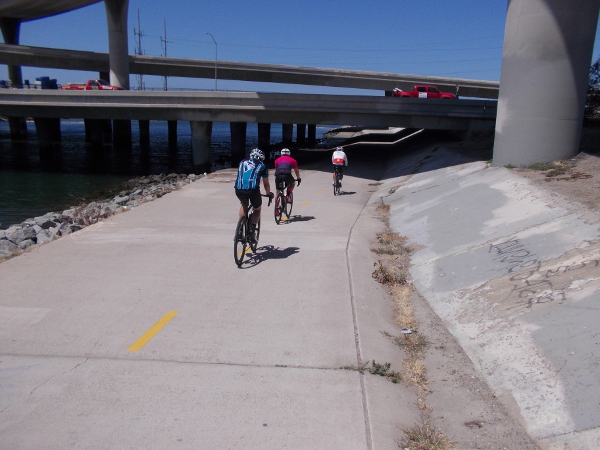 Bicyclists on Sweetwater Bikeway about to go under Interstate 5.