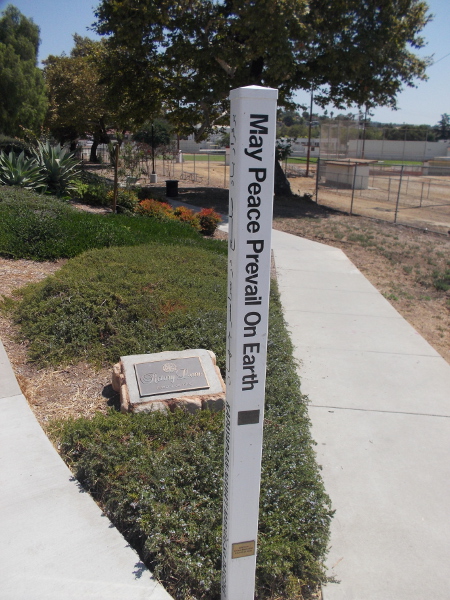 A pole at south end of Rotary Lane in Vista expresses May Peace Prevail on Earth in many languages. By the World Peace Prayer Society, 2018.