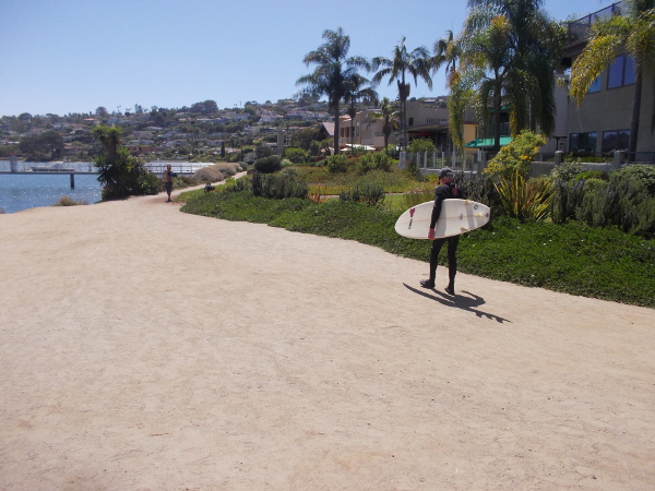 A surfer begins southwest down Point Loma’s Bessemer Path beside San Diego Bay.