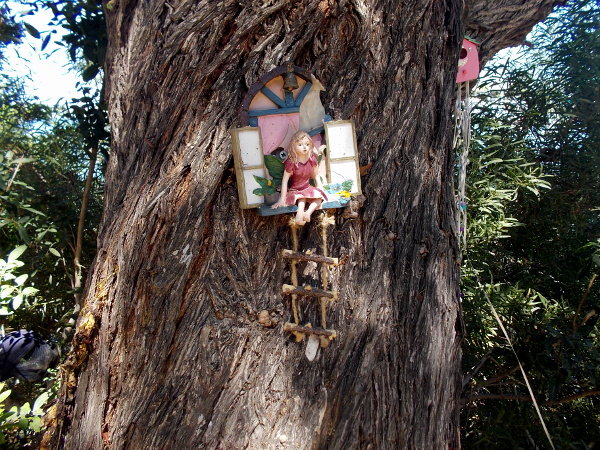 A girl sits in a window in the tree.