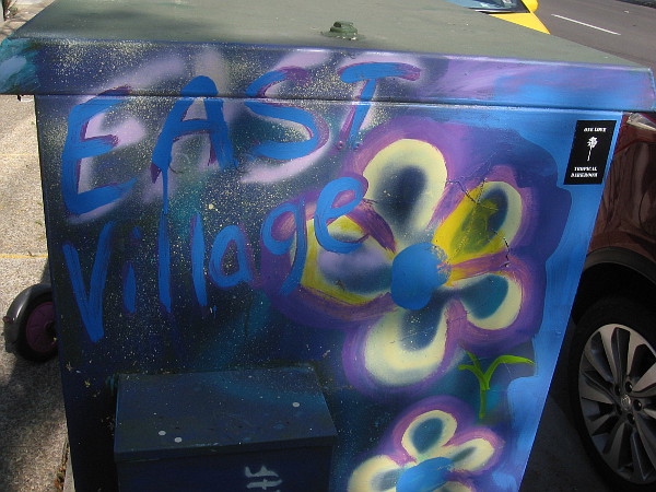 East Village painted on a sidewalk electrical box.