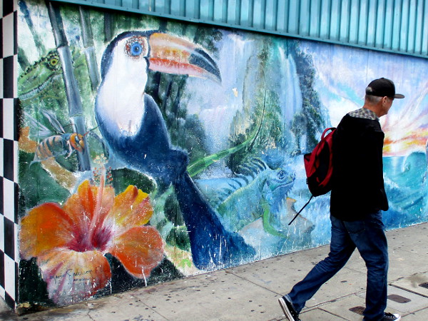 Somebody walks past a very colorful public mural in downtown Cardiff-by-the-Sea.