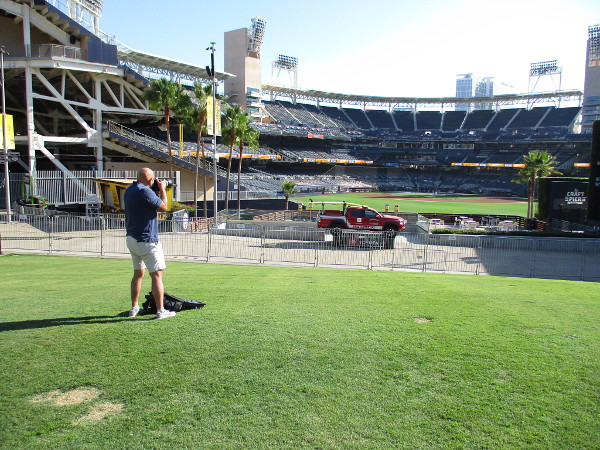 A photographer captures images of the Padres during batting practice.