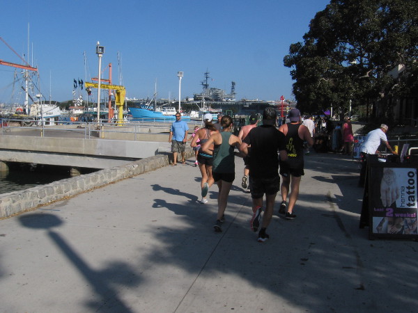 People walk and jog along San Diego's Embarcadero near Tuna Harbor.